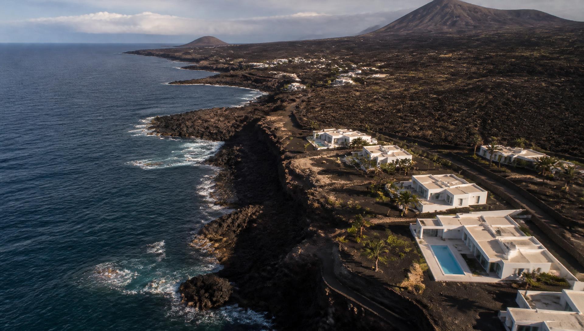 Aerial view of a volcanic coastline with luxury villas